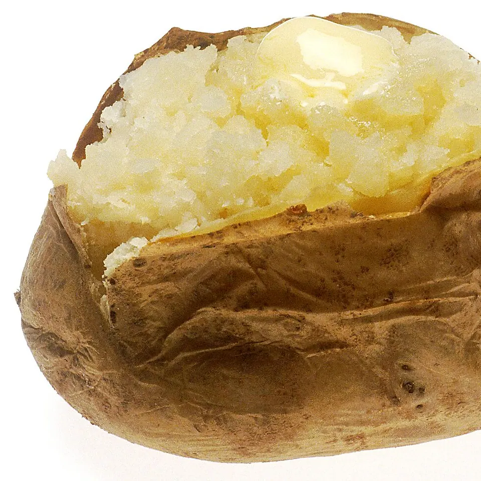 Papa al horno abierta y servida con manteca.